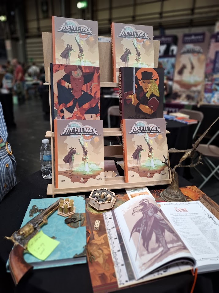 various tabletop roleplaying game books upon a table with dice and maps